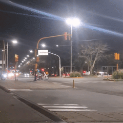 Motorcycles navigate nighttime intersection in Sarandí, Argentina