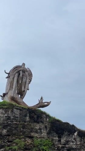 Weathered woman statue spotted on Nusa Penida coastal cliffs