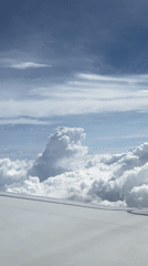 Passenger films clouds and wing from airplane window over Malaysia