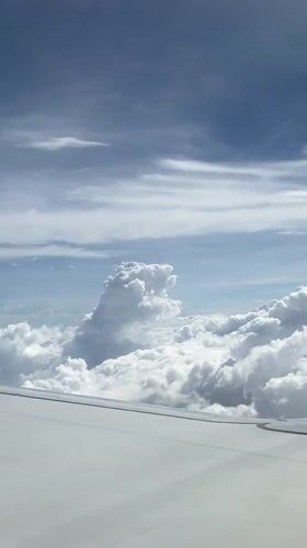 Passenger films clouds and wing from airplane window over Malaysia