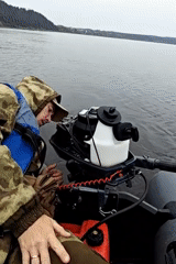Fishing trip on a broad Russian river with passing cargo traffic