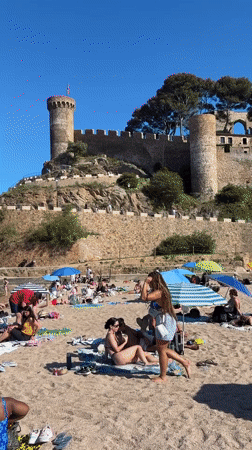 Tourists enjoy sunny afternoon at Tossa de Mar beach