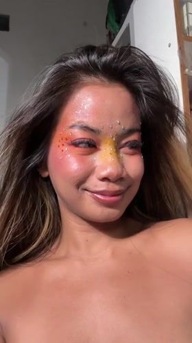 Woman poses with elaborate colorful makeup in North Jakarta