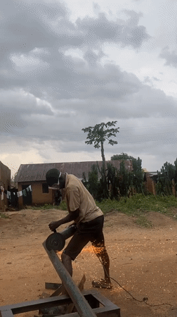 Man performs metal cutting work in Nigerian village yard