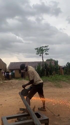 Man performs metal cutting work in Nigerian village yard