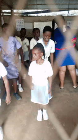 School kids in uniform gather and move around a Nigerian schoolyard