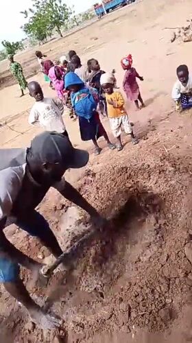 Man digs soil, poses for photos in Nigerian village