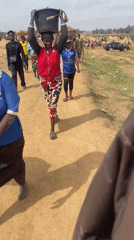 Rural residents carry soil buckets in Maiyanga, Nigeria