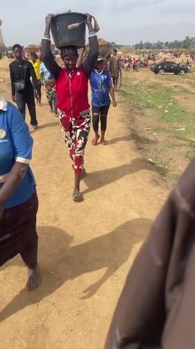 Rural residents carry soil buckets in Maiyanga, Nigeria