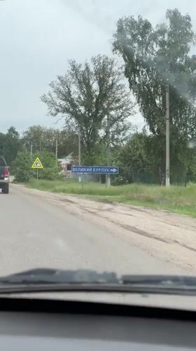 Vehicle travels past Velikiy Burluk road sign near Pechenihy