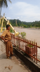 Damaged monument, uniformed observer documented in Simpangjaya riverside scene