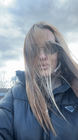 Woman takes windy selfie in Prada jacket, Latvia