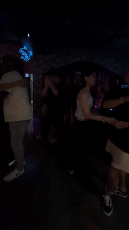 Couples dance salsa at Bangkok nightclub with neon lizard decor