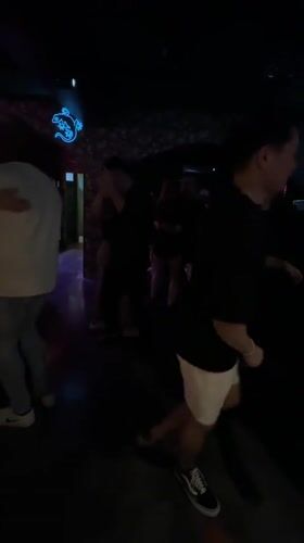 Couples dance salsa at Bangkok nightclub with neon lizard decor