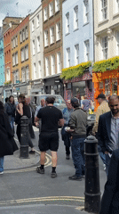 London street scene shows pedestrians among colorful buildings
