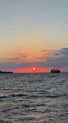 Sunset observed with cargo ship silhouette off Ischia coast