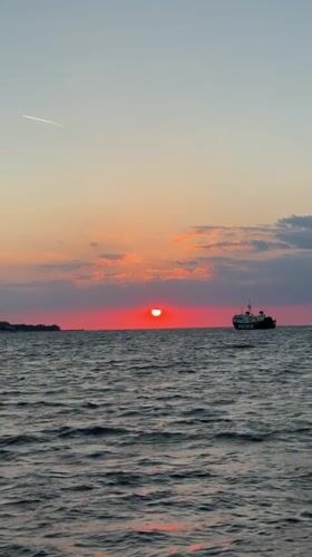 Sunset observed with cargo ship silhouette off Ischia coast