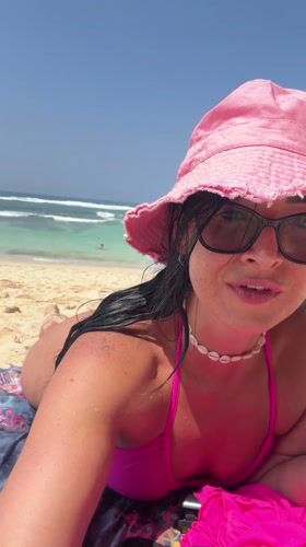 Woman documents beach day in pink bikini across Bali locations