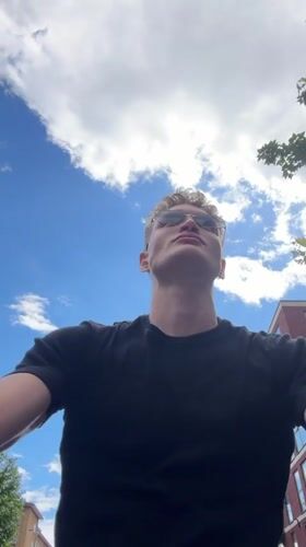 Young man gazes skyward in London afternoon