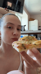 Woman enjoys pizza breakfast with cats in Russian home