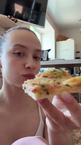 Woman enjoys pizza breakfast with cats in Russian home