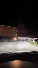 Train crosses road at night in Anevo, Bulgaria