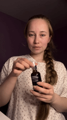 Woman applies skincare serum, drinks beverages in Saint Petersburg