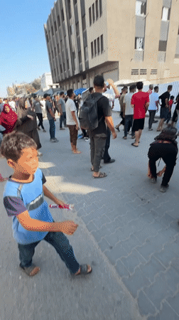 Red Crescent responders work scene outside damaged Gaza building