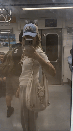 Commuter Takes Selfie in Seoul Subway Car Mirror