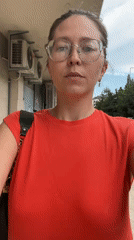 Woman in red walks through Podgorica carrying black purse