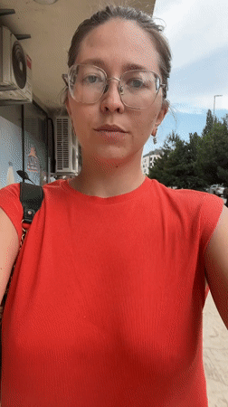 Woman in red walks through Podgorica carrying black purse