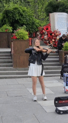 Violin played outdoors in a casual street-style outfit