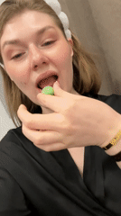 Woman in spa attire eats green candy in Kazan