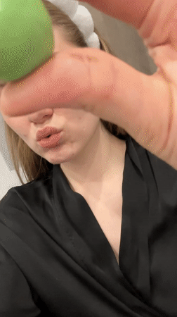 Woman in spa attire eats green candy in Kazan