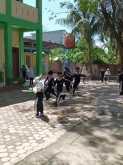Children in uniforms play with hula hoops in Lhokseumawe