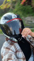 Motorcyclist in plaid shirt rides paved road in Mengwi