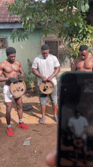 Three men hold weight plates in Akwanga yard