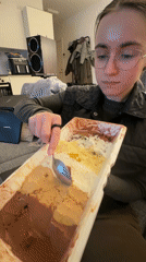 Woman samples multi-flavored ice cream on sofa in Copenhagen