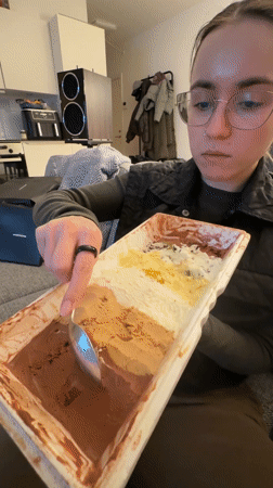 Woman samples multi-flavored ice cream on sofa in Copenhagen
