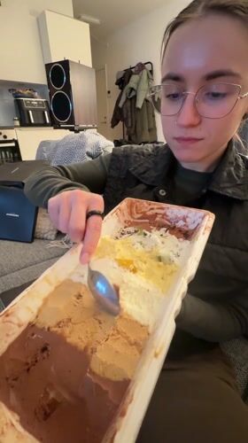 Woman samples multi-flavored ice cream on sofa in Copenhagen