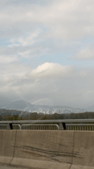 Vehicle travels bridge in Coquitlam with city view