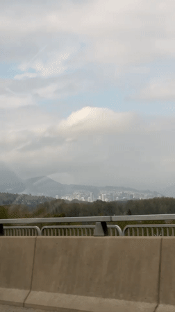 Vehicle travels bridge in Coquitlam with city view