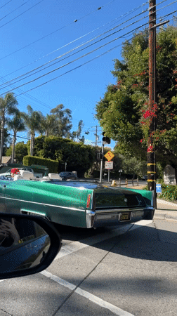 Green Cadillac convertible spotted driving through sunny Los Angeles streets