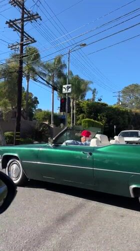 Green Cadillac convertible spotted driving through sunny Los Angeles streets