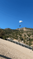 Paragliders soar over Fethiye beach as visitors enjoy clear skies