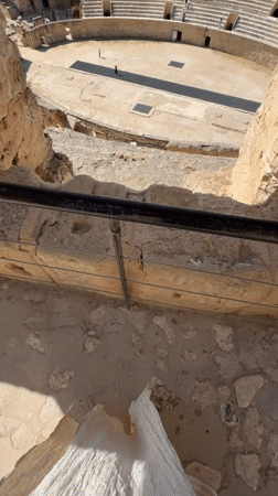 Tourist explores ancient Roman amphitheater ruins in Tunisia