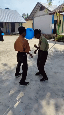 Blue balloon forehead game between two kids in school uniforms