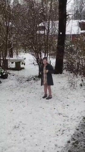 Woman photographed in snowy Kratovo garden during April snowfall