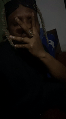 Person with dreadlocks recorded in dimly lit Jos bedroom