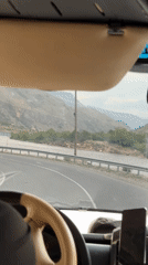 Vehicle journey documented through mountainous terrain with overcast skies